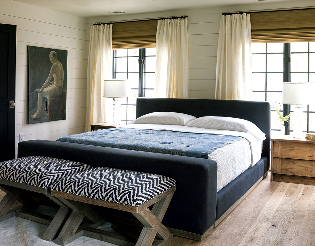 lauren-liess-vacation-home-master-bedroom - Washingtonian In one of the house’s three master bedrooms (top), moody blues impart a nautical feel. For the bunkroom (below) Liess went more literal, with vintage aquatic posters lining the shiplap walls. Photograph by Helen Norman.