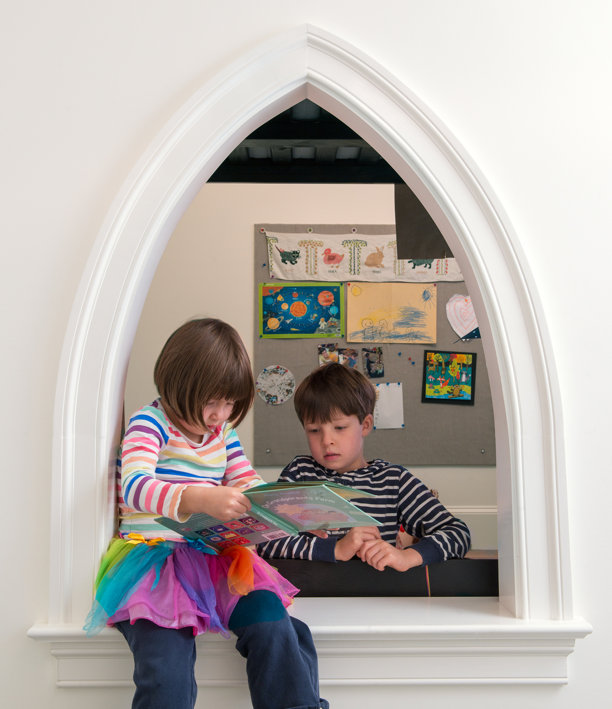 The kids’ rooms are connected with a Gothic-arch opening.
